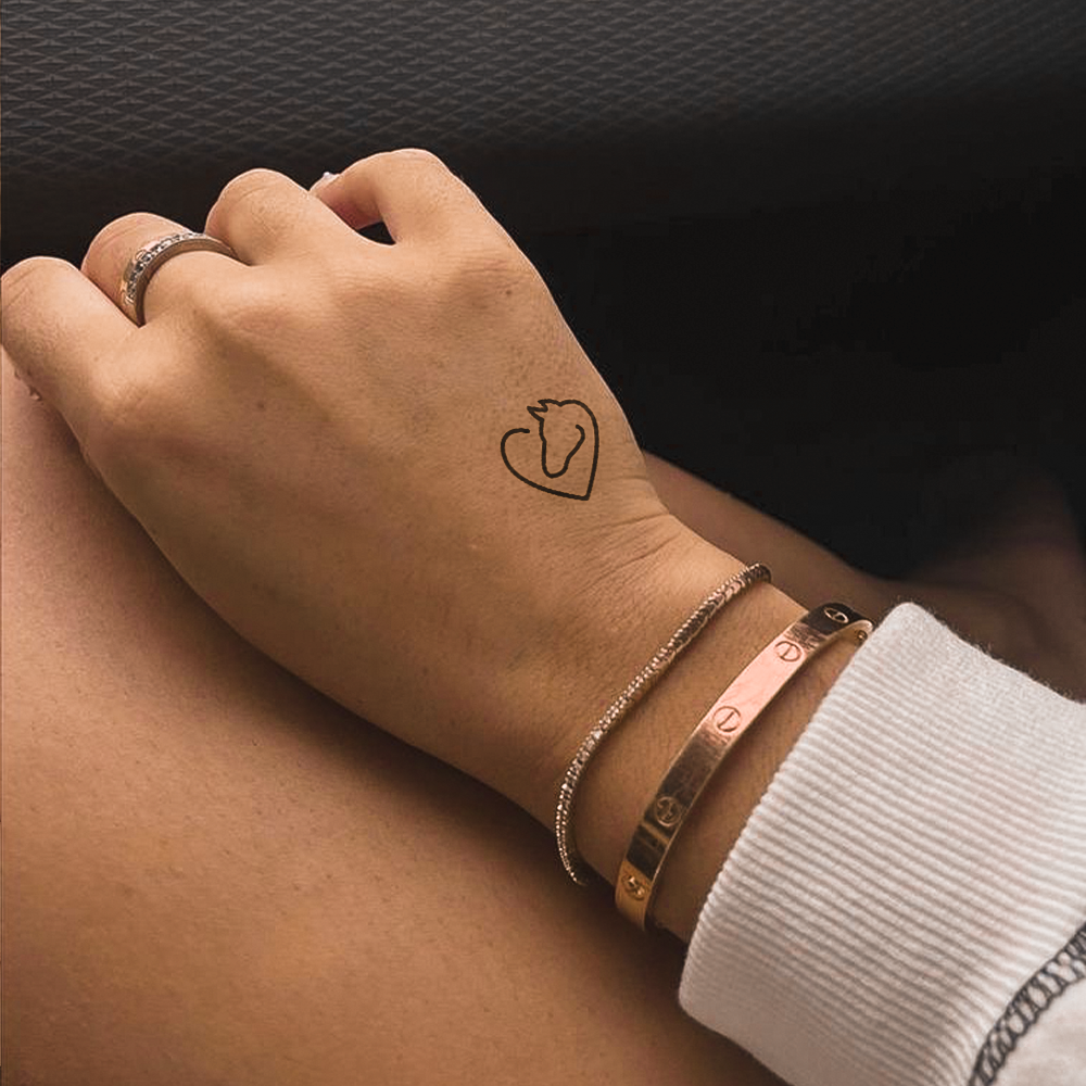 Tatuagem de coração com silhueta de cavalo